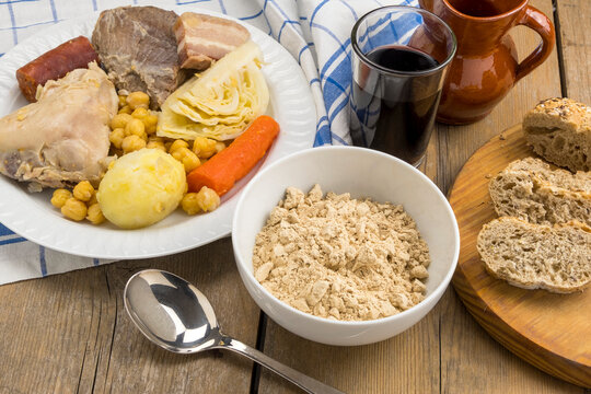 Puchero canario, gofio y vaso de vino tinto