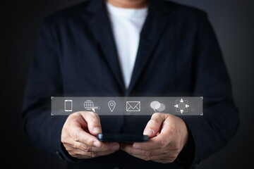 A businessman in a suit holds a smartphone with floating icons for contact options, including phone, email, location, chat, and global web, emphasizing accessibility and connectivity for contact us.