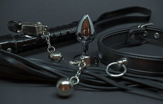 BDSM toys, a leather collar, nipple clamps, a whip and an anal plug