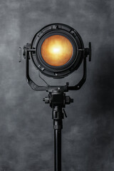 Black metal spotlight with adjustable barn doors, isolated on a solid grey background. 