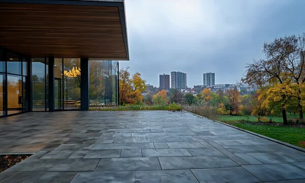 Modern Minimalist Patio with Glass Walls Overlooking an Urban Skyline Surrounded by Autumn Trees on a Cloudy Day