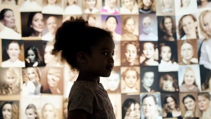 little black girl looks at a large screen on which historical photos of famous women are displayed