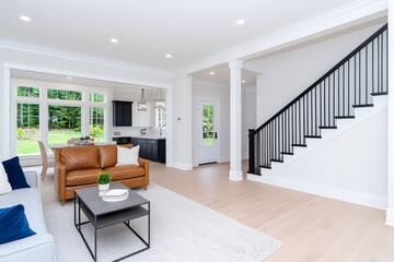 Fototapeta premium Stunning interior of a living room in a new luxury home featuring an open floor plan, including the entryway, stairs, kitchen, and dining area