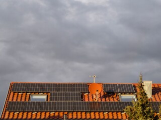 Solar panels in sunshine on a day with dark clouds