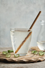 A glass of fresh aloe vera juice with green sliced leaf with ecological bamboo straw. Zero waste.