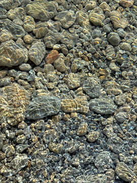 Pebbles stones gravel in crystal clear water.