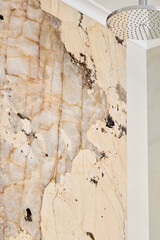 An Elegant Marble Wall Design that features a Modern Showerhead for a luxurious space