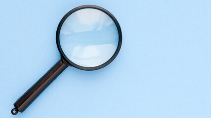 Black magnifier on a blue background.
