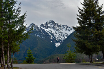 Man shooting photography under snowy mountain, North Cascades National Park, Washington