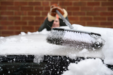 Cleaning snow off a white car