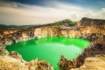 Fototapeta premium Volcanic Crater Lake: The vibrant green waters of a volcanic crater lake