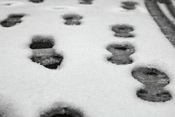 Footprints in fresh snow reveal a winter walk through a quiet neighborhood on a peaceful morning