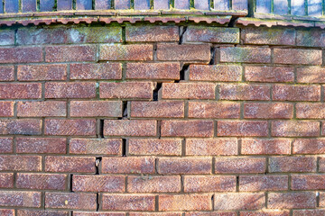 A large crack running through a brick wall