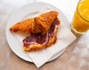 Delicious baked croissant with ham served on platter