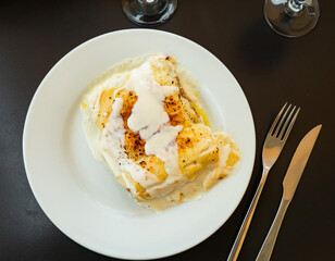 Appetizing rolls with minced meat, cheese and sauce. Traditional Italian dish Canelone de carne