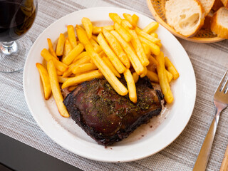 Delicious roasted pork steak served with vegetable garnish of crispy fries