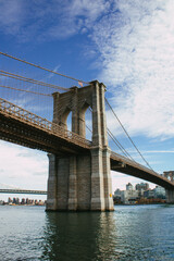 Obraz premium Majestätische Brooklyn Bridge über dem East River bei blauem Himmel