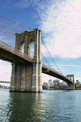 Obraz premium Majestätische Brooklyn Bridge über dem East River bei blauem Himmel