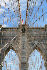 Seilstruktur und Pfeiler der Brooklyn Bridge mit amerikanischer Flagge