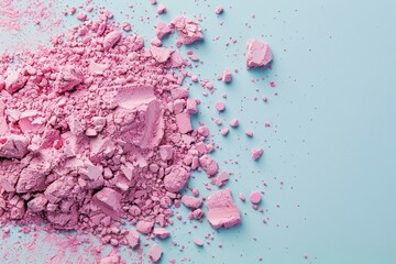 Crashed pink eyeshadow or blushes on light blue background. Dry facial products or decorative cosmetics advertisement, close-up, copy space