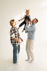 Mom and dad playing with a child on a white background