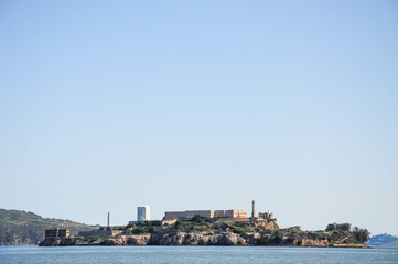 Alcatraz Island under clear sky, surrounded by tranquil San Francisco Bay waters