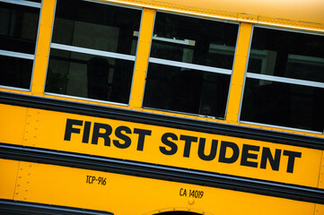 Yellow school bus with 'First Student' logo, showcasing iconic design.