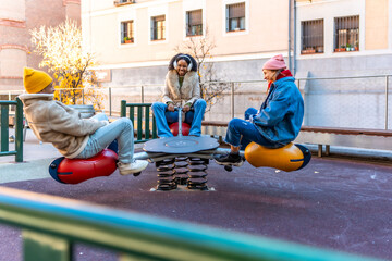 Young people having fun on a seesaw in winter city playground
