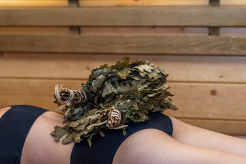 Young woman relaxing in hot sauna. Interior of Finnish sauna, classic wooden sauna with hot steam. Russian bathroom