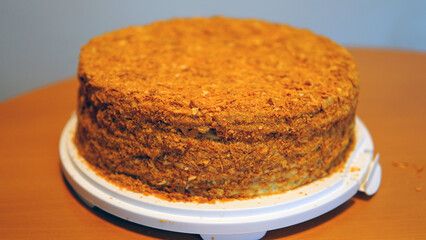 A close-up of a sumptuous Napoleon cake with multiple flaky layers filled with rich cream, topped with crumbled pastry for a delightful texture