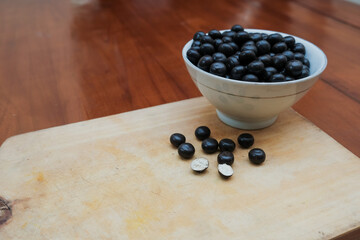 Ball biscuit wafer with chocolate coating on white bowl in the wooden cutting board. sweet snack