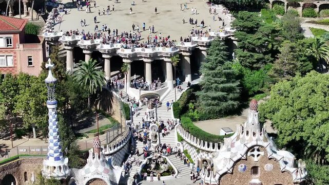 A close-up view of Parc G&uuml;ell in Barcelona, Spain, with tourists enjoying Gaud&iacute;&rsquo;s artistic designs, colorful mosaics, and the park&rsquo;s unique atmosphere.