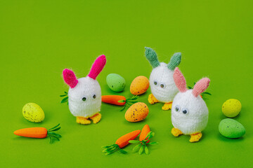 Handmade Easter concept. Knitted bunnies with traditional decoration. Festive symbols, greeting card