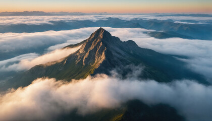 Majestic mountain peak rising above the clouds at sunrise, showcasing stunning natural beauty and tranquility