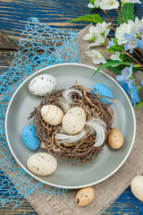Easter table setting with eggs, bird's nest and blooming branch. Traditional festive symbols
