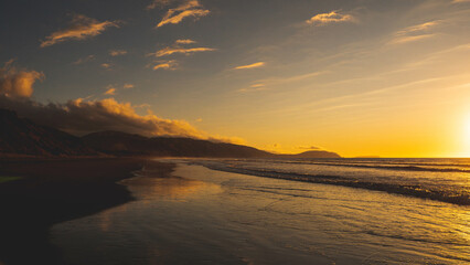 Sunning sunset sun setting into sea ocean water kapiti coast new zealand gold colour