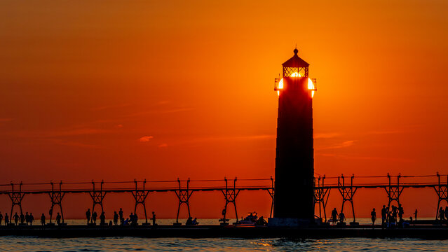 The lighthouse pier at Grand Haven, Michigan, shown in silhouette as the sun sets over Lake Michigan