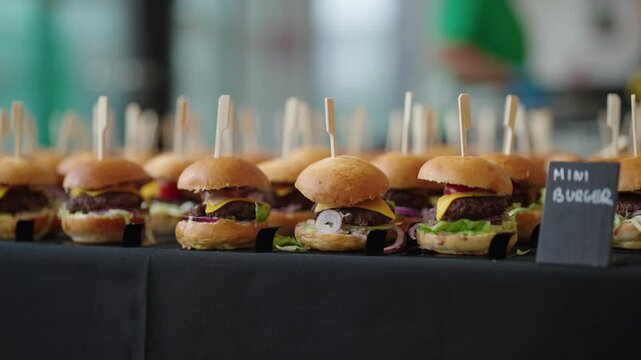 mini hamburgers arranged in rows, catering service at the event