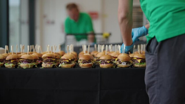 mini hamburgers arranged in rows, catering service at the event
