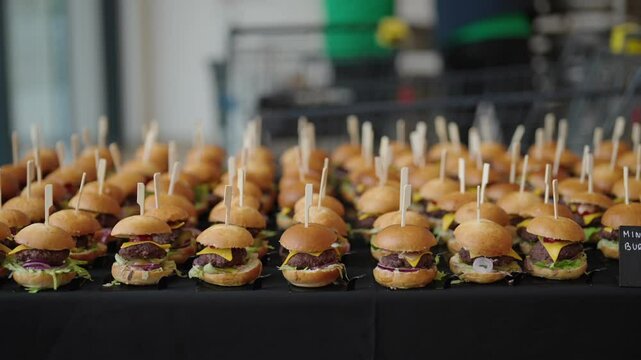 mini hamburgers arranged in rows, catering service at the event