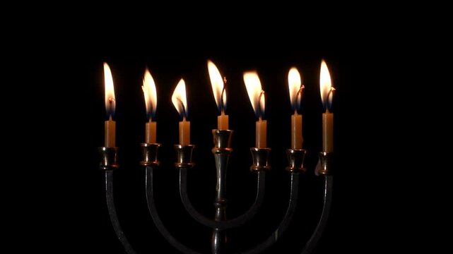 Hanukkah menorah with burning candles on black background. Jewish symbol.
