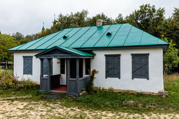 A small house with a green roof and white walls
