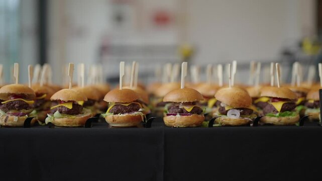 mini hamburgers arranged in rows, catering service at the event