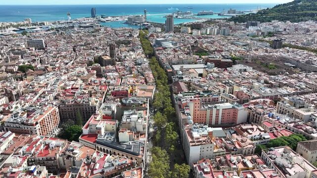 A dynamic aerial view of La Rambla in Barcelona, Spain, filled with people enjoying the lively atmosphere of this iconic street in the heart of the city.