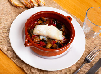 Appetizing stewed cod served with samfaina vegetables in restaurant