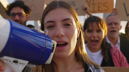 Group of diverse people manifesting against war or attack on a country. Female activist leading a demonstration using megaphone outdoors. Stop war signs and banners in a peace demonstration