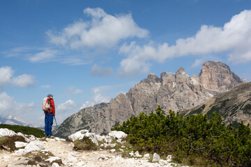 Naklejka premium Man hiking along mountainous alpine landscape in Dolomite Alps in Italy