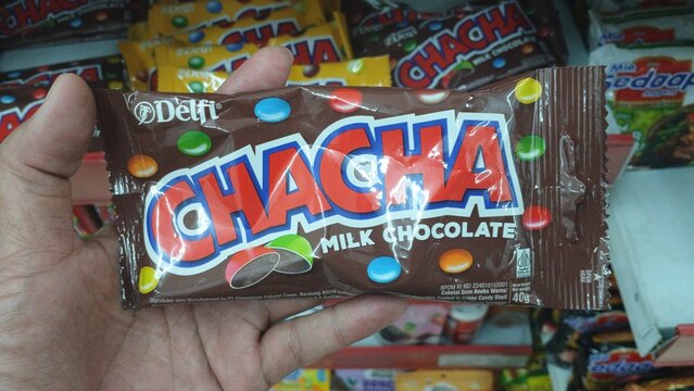 Hand holding Cha cha snack. Cha cha is peanut with milk chocolate which produced by Delfi