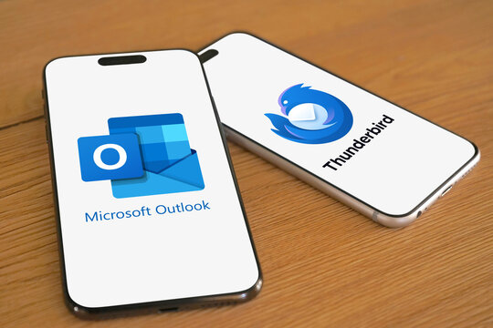 Microsoft Outlook and Thunderbird logos are displayed on two smartphones next to each other, e-mail client, with functions as calendaring, messages, contact managing, notes, organization, filter