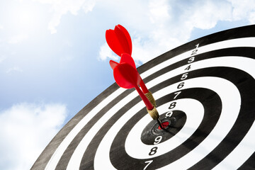 Two arrows on target board with sky background